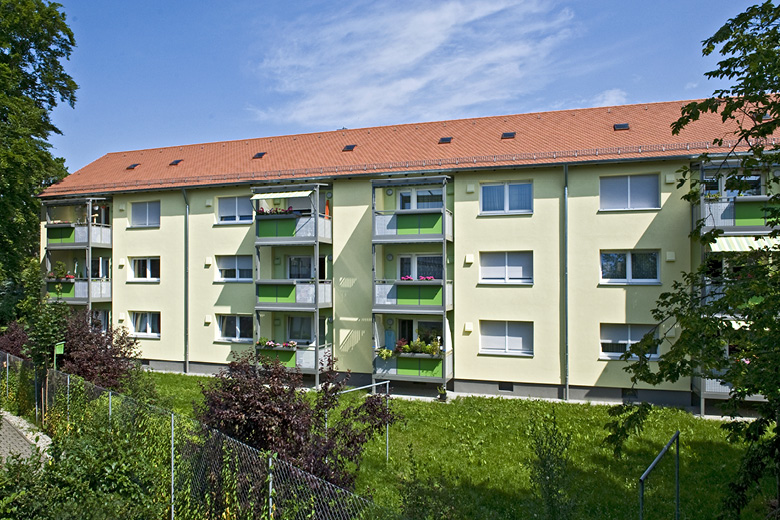 Mehrfamilienhaus in der Eckenstraße 28-28a in Nürnberg, Rückansicht mit grünen Balkonen und begrüntem Hang