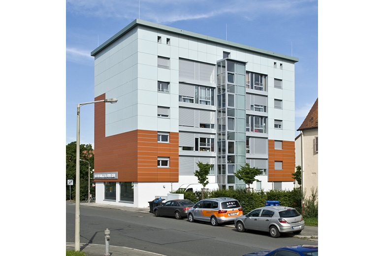Modernes mehrgeschossiges Gebäude in der Fallrohrstraße 63 in Nürnberg mit weiSSer und orangefarbener Fassade, Rückansicht