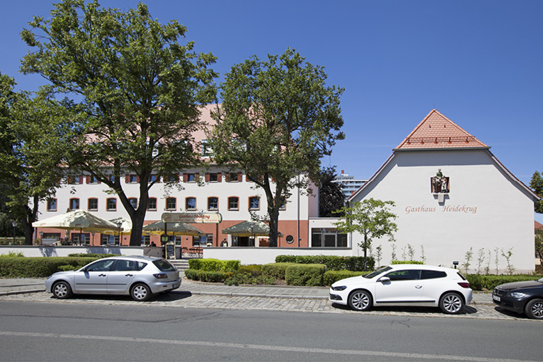 Gasthaus Heidekrug in Nürnberg, historisches Gebäude mit Satteldach, Straßenansicht mit parkenden Autos