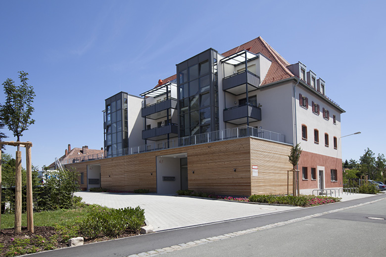 Ehemaliges Gasthaus Heidekrug in Nürnberg, modernisiertes Wohngebäude mit Glasbalkonen und Holzverkleidung, Rückansicht