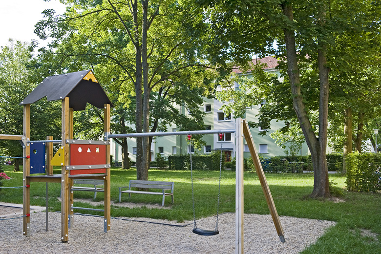 Spielplatz mit Klettergerüst, Schaukel und Sitzbank vor dem Wohnhaus Goldweiherstraße 37-41 in Nürnberg