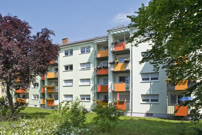 Mehrfamilienhaus in der Goldweiherstraße 37-41 in Nürnberg, Rückansicht mit orangen Balkonen und Garten