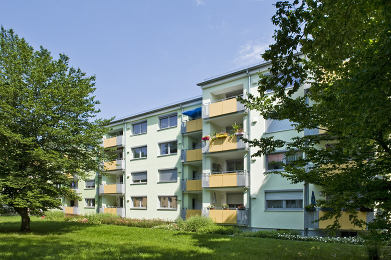Mehrfamilienhaus in der Goldweiherstraße 43-47 in Nürnberg, Rückansicht mit Balkonen, Rasenfläche und altem Baumbestand