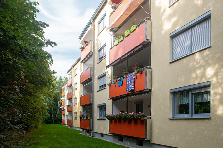 Mehrfamilienhaus in der Goldweiherstraße 55-59 in Nürnberg, Rückansicht mit orangen Balkonen und Blumenkästen