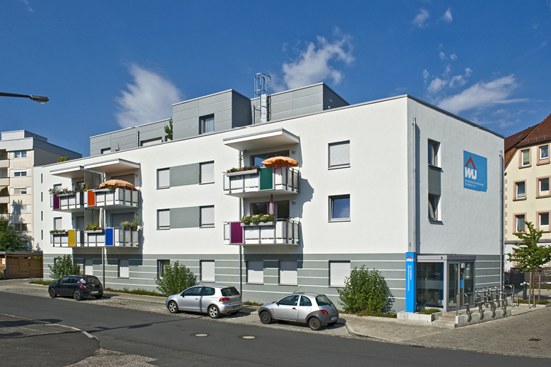 Gebäude des Wohnungsunternehmens Nürnberg-Ost in der Kachletstraße 6, Frontansicht mit Balkonen, Firmenlogo und Parkplätzen