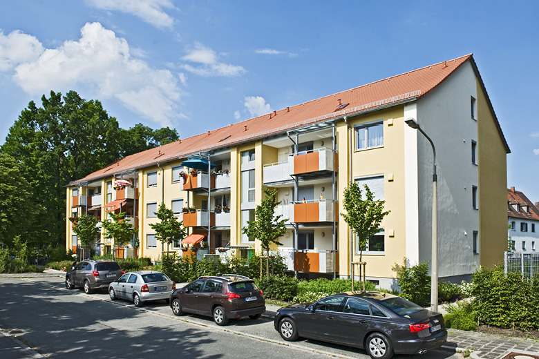 Mehrfamilienhaus in der Passauerstraße 50-52 in Nürnberg, Frontansicht mit Balkonen und Straße mit parkenden Autos