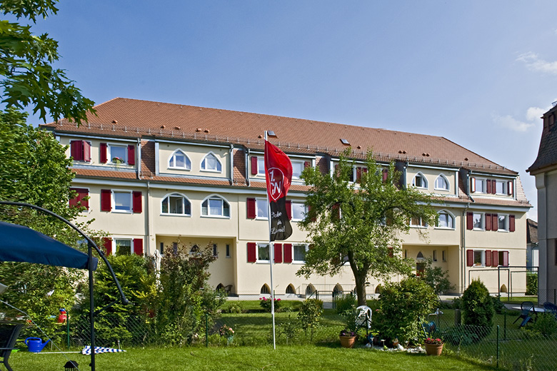 Wohnhaus in der Rohrmattenstraße 5-7 in Nürnberg, Rückansicht mit Garten, Fahnenmast und roten Fensterläden