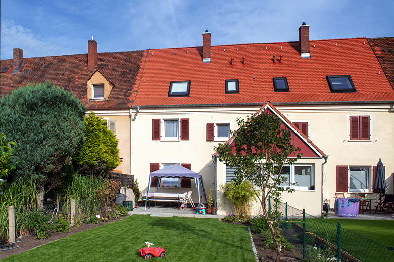 Reihenhaus in der Waldluststraße 21-49 in Nürnberg, Rückansicht mit Garten, Sitzgruppe und Kinderspielzeug